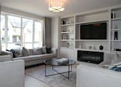 Thumbnail 1 of 4 - a living room with a couch and a table and a television