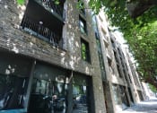Thumbnail 7 of 7 - a tall brick building with glass windows and a sidewalk