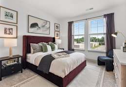 A well-lit bedroom with a large bed and a green carpet. at Portrait Midtown Apartments, Indiana, 46032