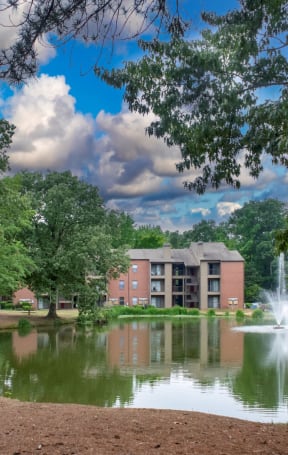 a pond with a fountain and a building in the background at The Summit Apartments, Memphis, TN