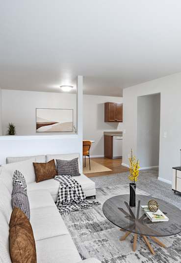 A living room with a white couch, a coffee table, and a large painting on the wall.