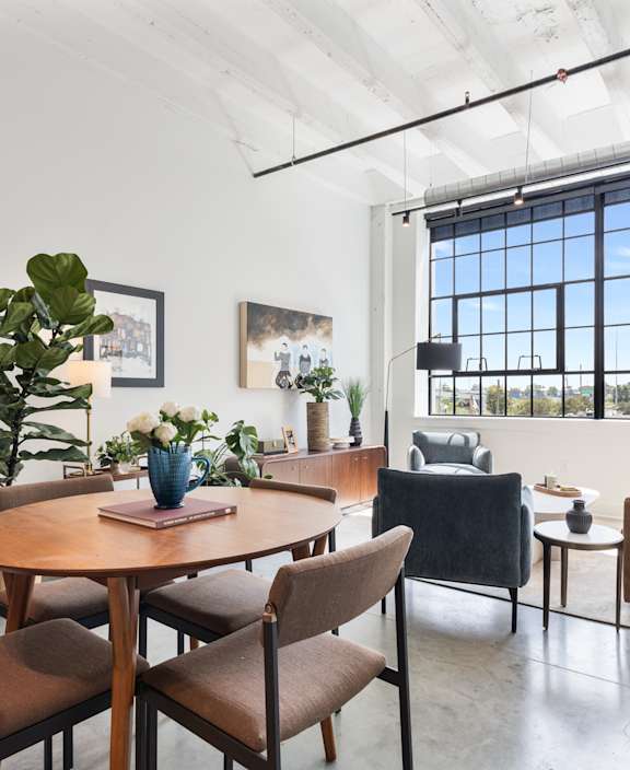 A modern living room with a dining table and chairs.