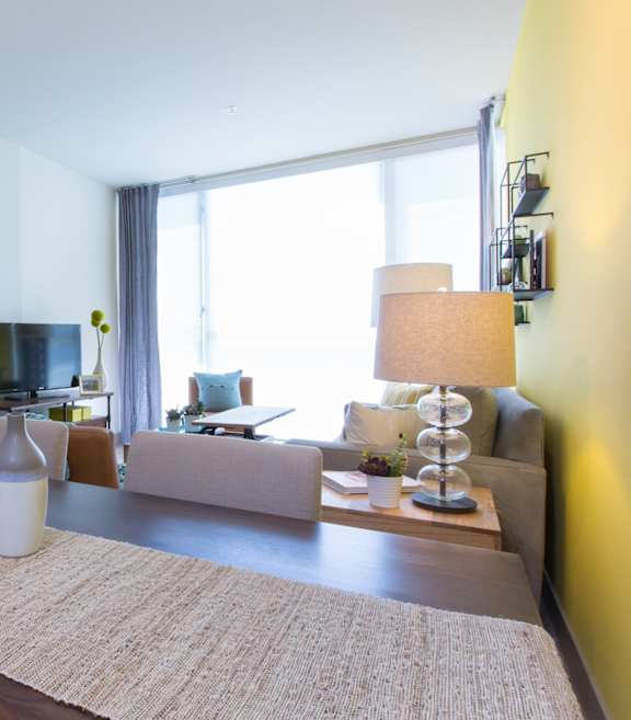 A well-lit bedroom with a large bed and a couch.
