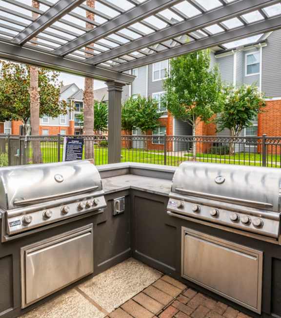 Patio with a grill and a pergola at The Fenwick Apartment Homes, Humble, TX