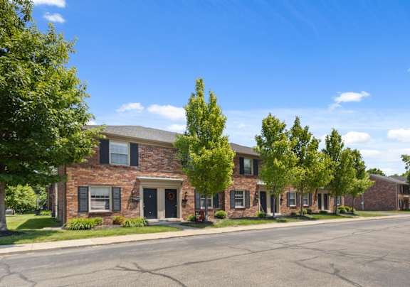 Classic red-brick townhome exterior at Monon Place I in Broad Ripple featuring dual private entrances and lush landscaping near the Monon Trail.