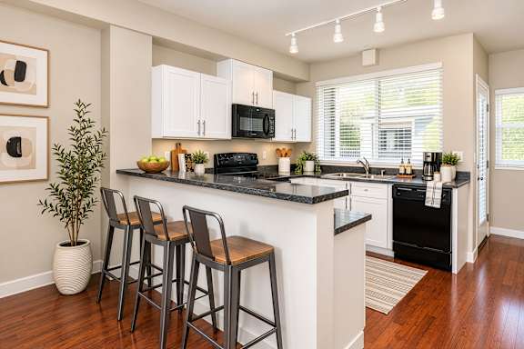 A kitchen with a black countertop and white cabinets.