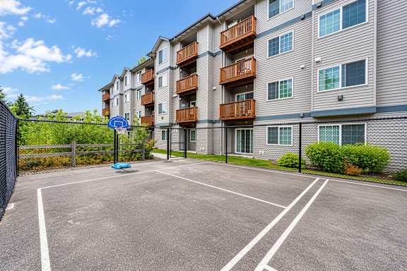 A parking lot in front of a residential building.