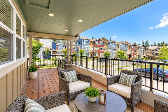A balcony with a table and chairs overlooking a row of houses.