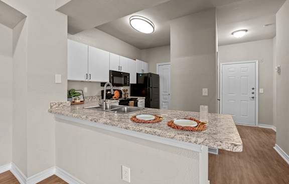 A kitchen with a white stove and microwave above a white oven.