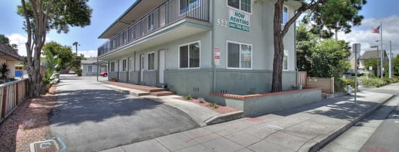a building with a street and trees in front of it