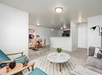 A living room with a grey couch and a white coffee table.