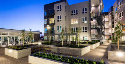 A modern building complex with a courtyard and plants.