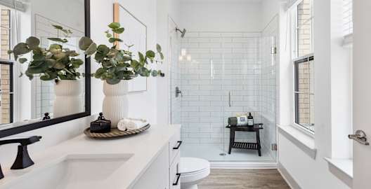 A white bathroom with a white sink and a white toilet.