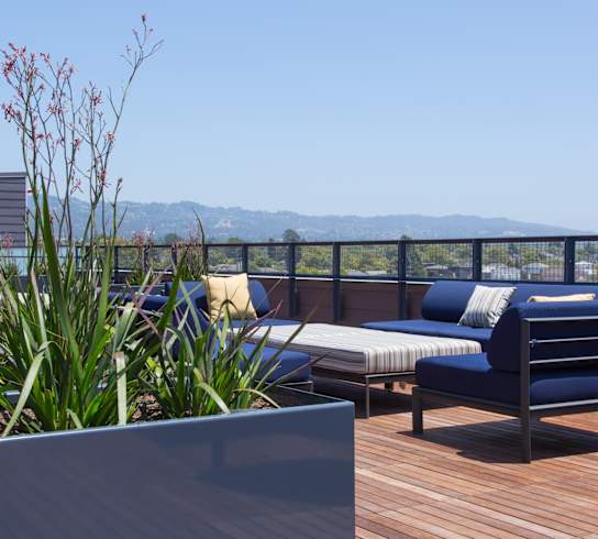 A wooden deck with a bench and a planter box.