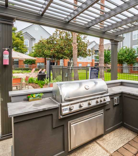 Patio with a grill and a pergola at The Fenwick Apartment Homes, Humble, TX