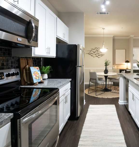 a kitchen with a marble counter top and a stainless steel refrigerator at The Beck at Hidden River, Tampa, FL, 33637
