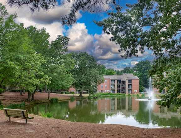 a pond with a fountain and a building in the background at The Summit Apartments, Memphis, Tennessee