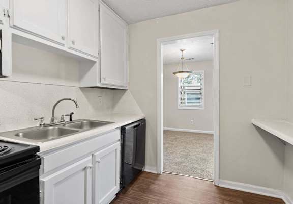 A kitchen with white cabinets and a black stove top oven.