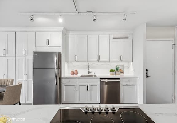 a kitchen with white cabinets and a stainless steel refrigerator