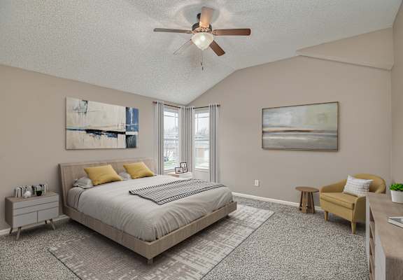 A bedroom with a large bed and a ceiling fan.