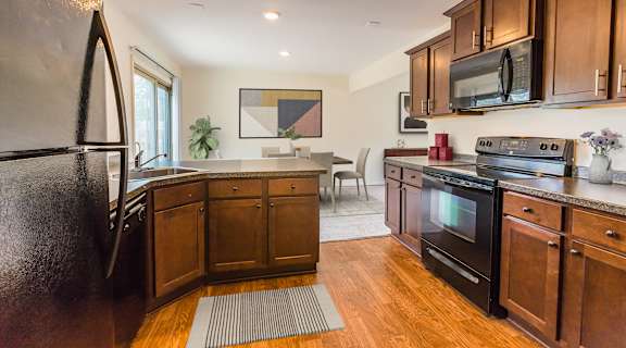 a kitchen with dark wood cabinets and stainless steel appliances