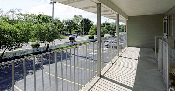 the view from the porch of a building with white metal railings