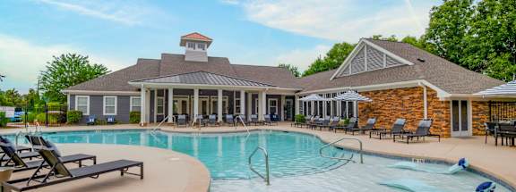 A pool with a house in the background at Ansley at Town Center Apartments, Georgia