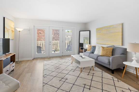 Modern living room at Monon Living in Broad Ripple featuring sleek furnishings, bright natural light, and direct access to a private patio near the Monon Trail.