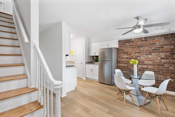 Contemporary kitchen and dining area at Monon Living in Broad Ripple featuring exposed brick, stainless steel appliances, and direct trail access via the Monon.