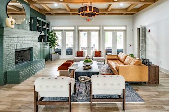 A living room with a green fireplace and a large chandelier.