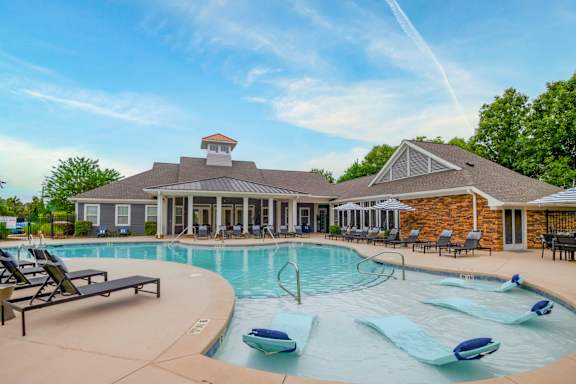A pool with a house in the background.
