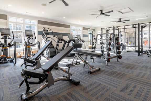 A gym with a variety of equipment including treadmills, stationary bikes, and weight machines.at The One at Millington, Millington, 38053