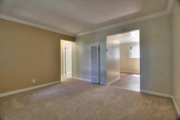 A room with wooden floors and a window with blinds.