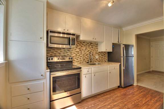 A kitchen with white appliances and cabinets.