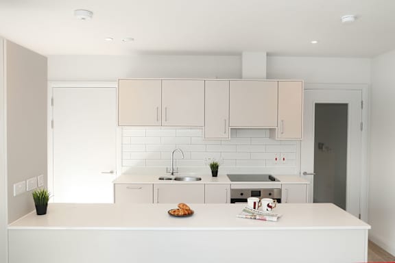 a white kitchen with white cabinets and a white counter top
