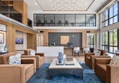 A living room with brown couches and a large painting on the wall.