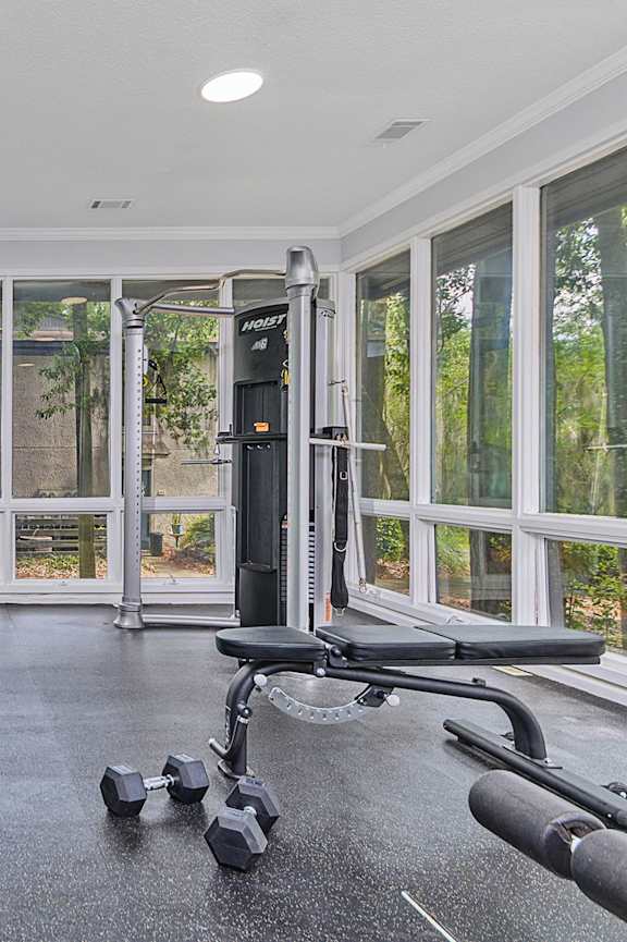 A gym with a variety of equipment including treadmills, weights, and exercise machines.