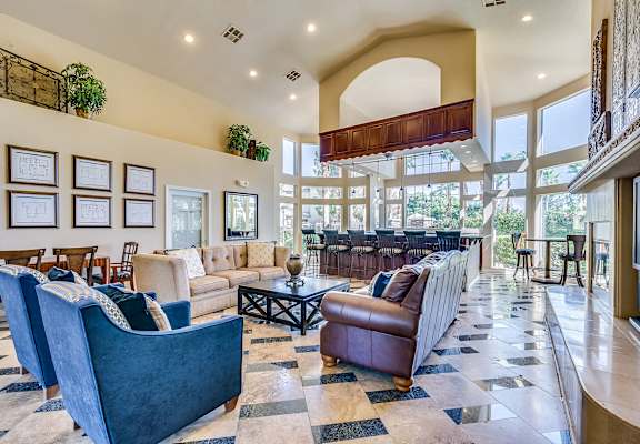 A living room with a blue couch and a brown leather chair.