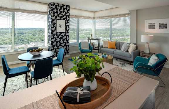 A living room with a table, chairs, and a view of the outdoors.