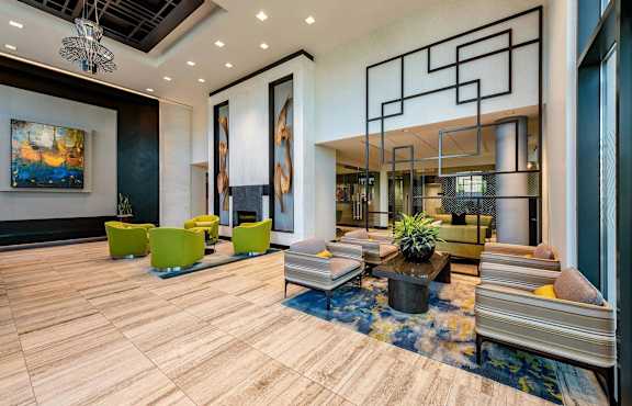 A modern living room with a wooden floor and a large abstract painting on the wall.