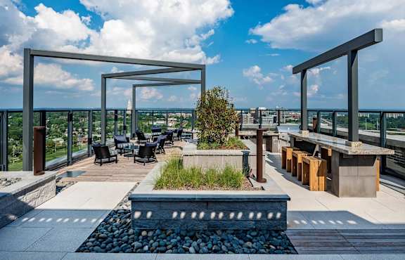 A patio with a table and chairs overlooking a cityscape.