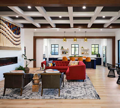 A living room with a red couch and a fireplace.