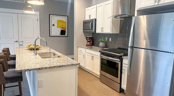 a kitchen with white cabinets and stainless steel appliances