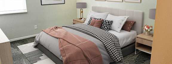 A bedroom with a bed and pictures on the wall at Briarlane Apartments in Grand Rapids, Michigan