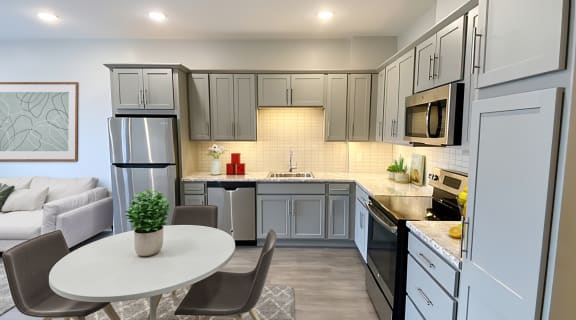 a kitchen with gray cabinets and a white table and chairs