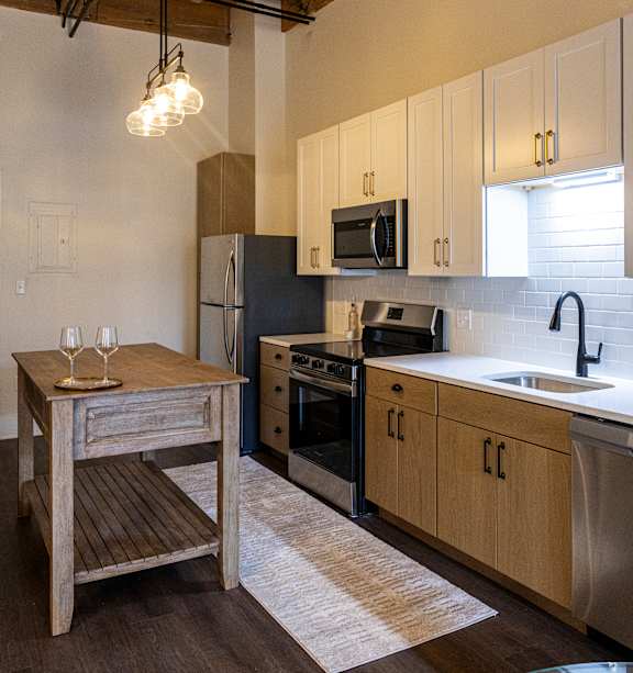 A kitchen with a wooden table and stainless steel appliances. at The Dean at Creekview Apartments, Newark, Delaware