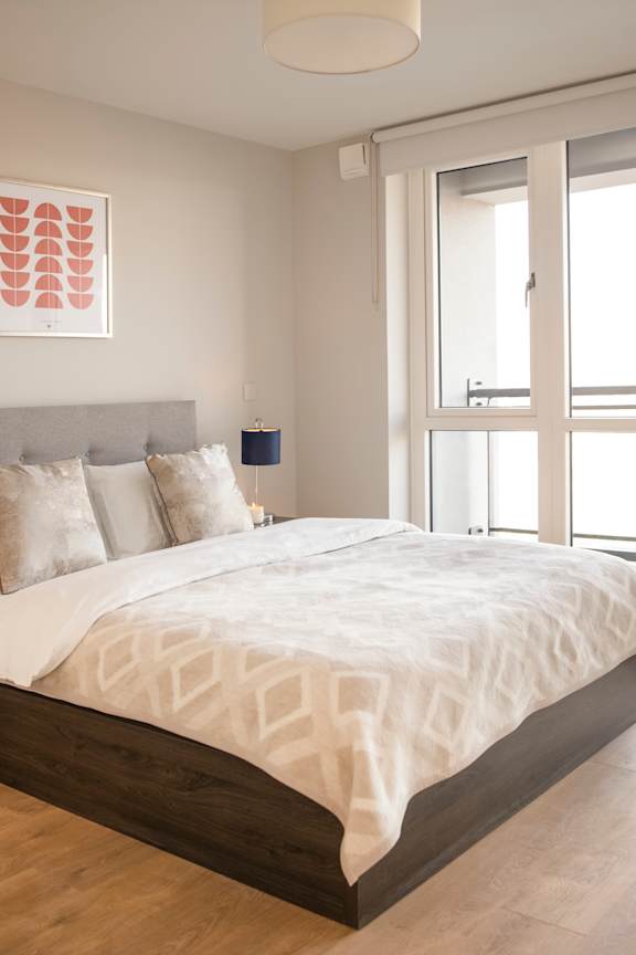 a bedroom with a large bed and a window
