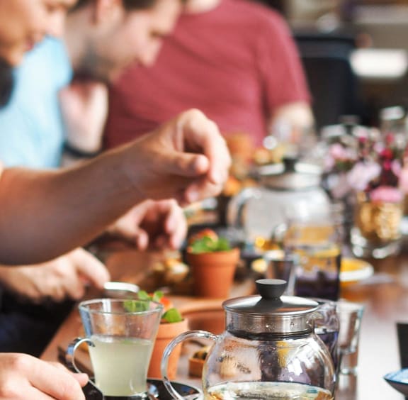 a group of people sitting around a table eating food at a restaurant