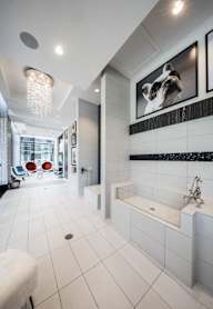 A white bathroom with a tub and a picture of a bulldog.