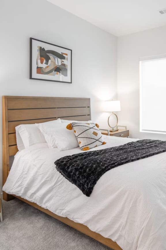 a bedroom with a bed and a desk and a window